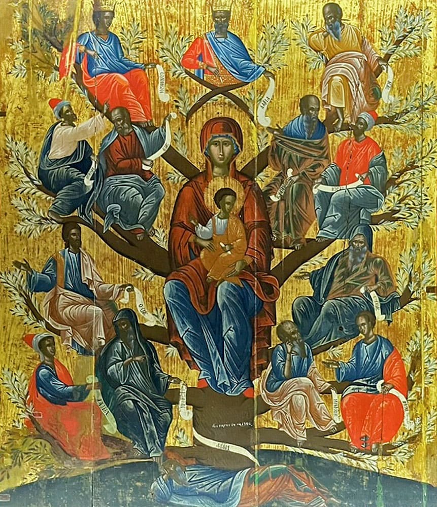 A religious icon depicts the Virgin Mary holding the Christ child, seated at the center of a tree with various saints or prophets in colorful robes on its branches, all set against a gold background.